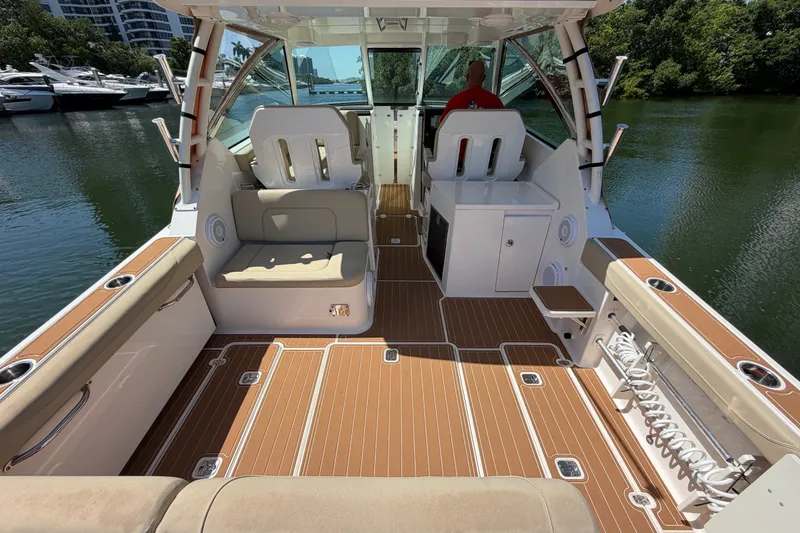 Slide: The Image of 2016 Pursuit DC 325 Dual Console boat interior with seating and wood flooring. - 17