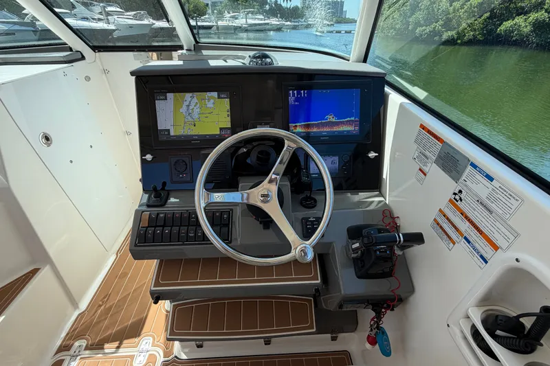Slide: The Image of Helm of 2016 Pursuit DC 325 Dual Console with navigation screens and controls. - 31