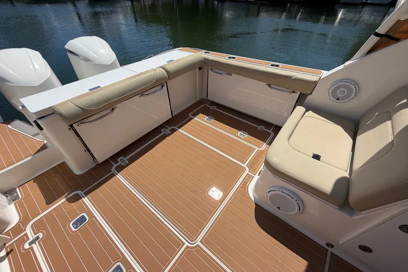 Slide: The Image of 2016 Pursuit DC 325 Dual Console boat interior with cushioned seating and teak flooring. - 15