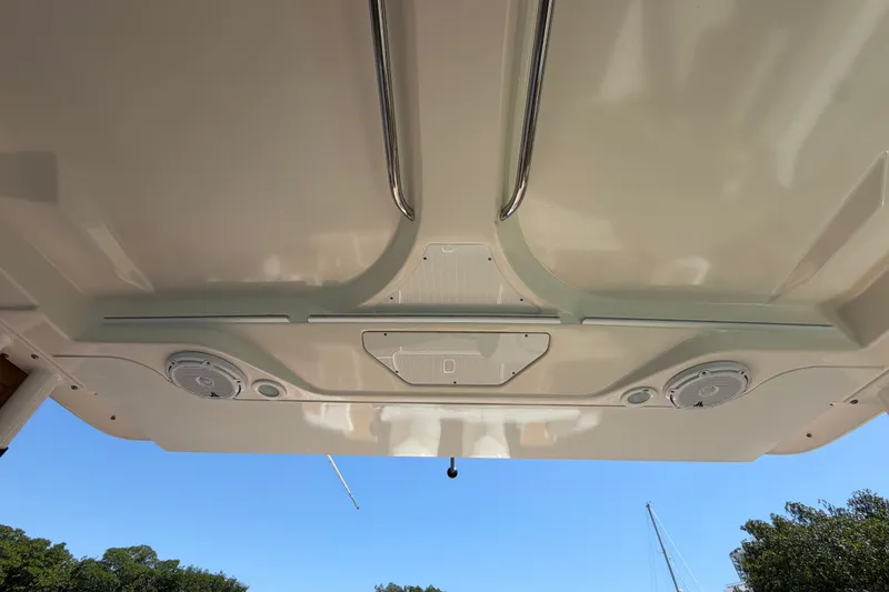 Slide: The Image of 2016 Pursuit DC 325 Dual Console boat ceiling with speakers and handles. - 23