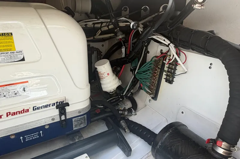 Slide: The Image of Engine compartment of a 2016 Pursuit DC 325 Dual Console with generator and wiring. - 59