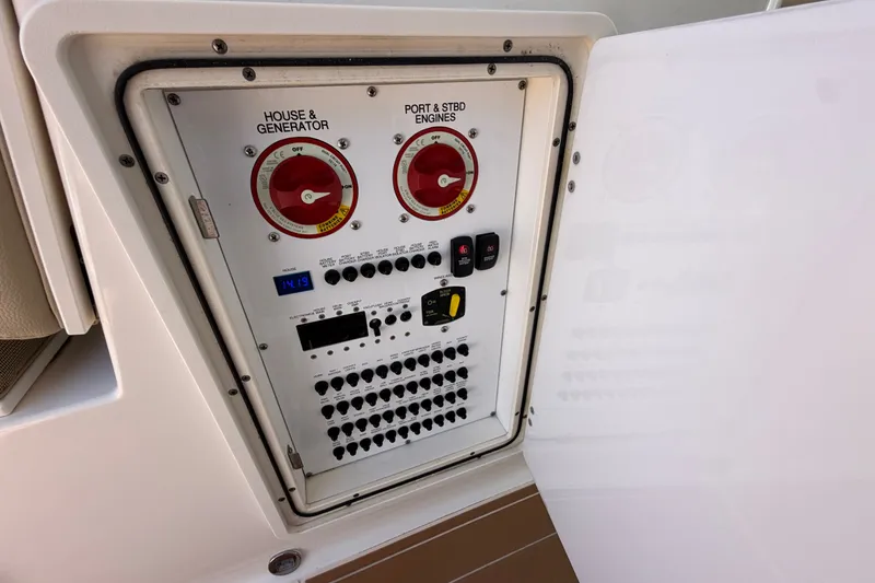 Slide: The Image of Control panel of a 2016 Pursuit DC 325 Dual Console boat, featuring switches and gauges. - 26
