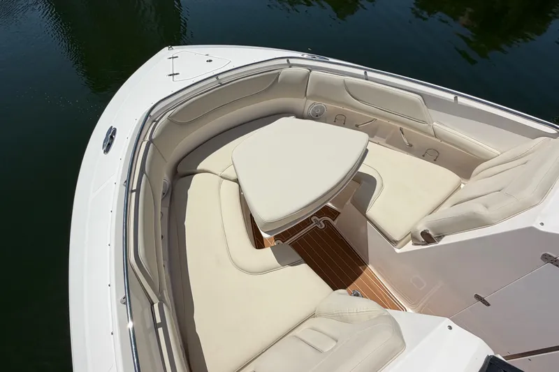 Slide: The Image of 2016 Pursuit DC 325 Dual Console boat with luxurious seating and table on calm water. - 51