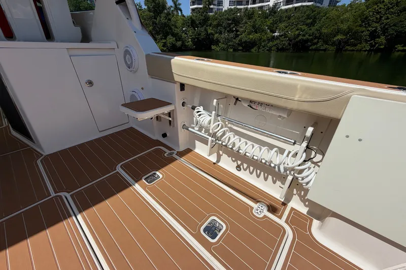 Slide: The Image of 2016 Pursuit DC 325 Dual Console boat interior with teak flooring and storage features. - 18