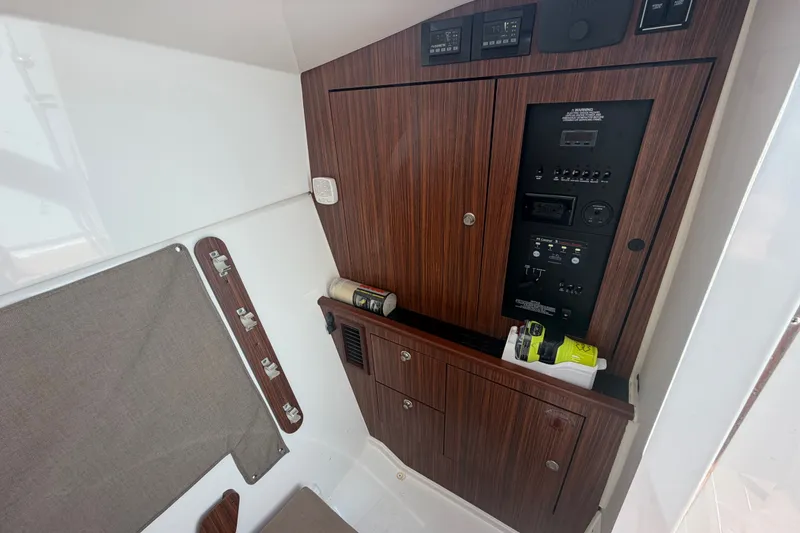 Slide: The Image of 2016 Pursuit DC 325 Dual Console interior with wood paneling and control panel. - 46