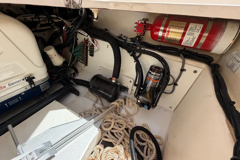 Slide: The Image of 2016 Pursuit DC 325 Dual Console engine compartment with generator, fire extinguisher, and ropes. - 56
