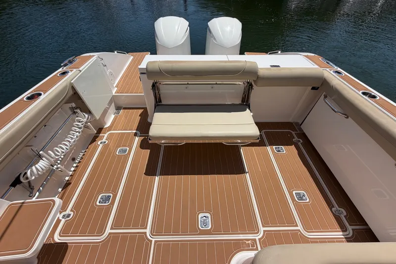 Slide: The Image of 2016 Pursuit DC 325 Dual Console boat deck with seating and storage compartments. - 10