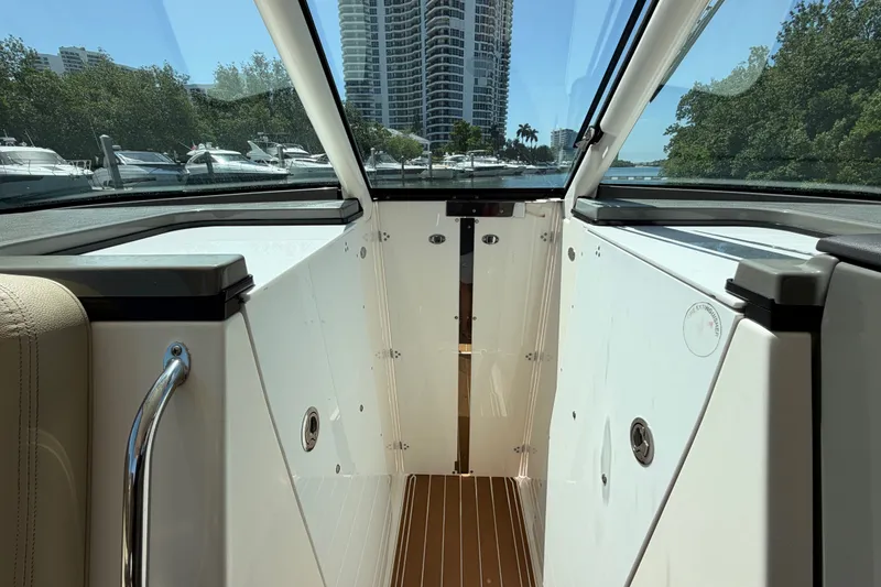 Slide: The Image of Interior view of a 2016 Pursuit DC 325 Dual Console boat with cityscape background. - 43
