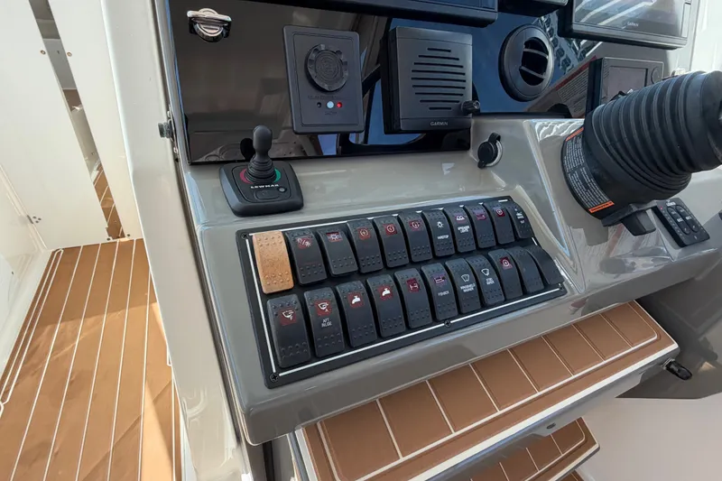 Slide: The Image of Control panel of a 2016 Pursuit DC 325 Dual Console boat with switches and joystick. - 33