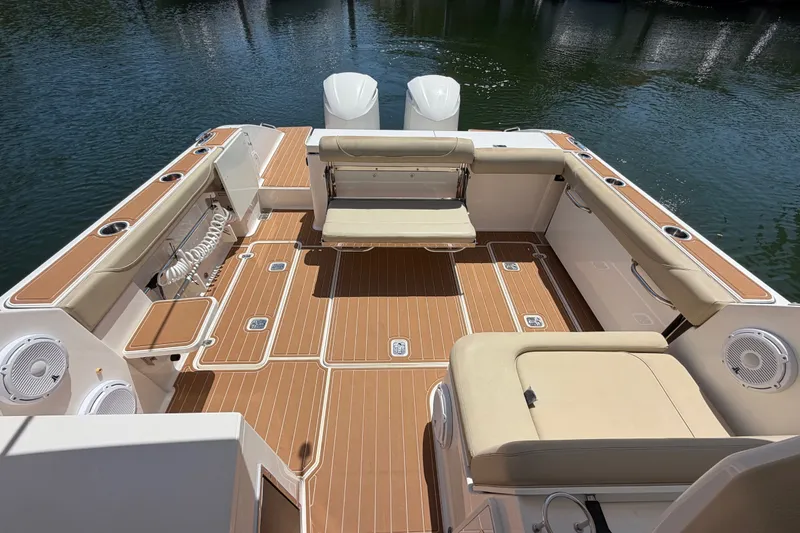 Slide: The Image of 2016 Pursuit DC 325 Dual Console boat interior with spacious seating and teak flooring. - 9