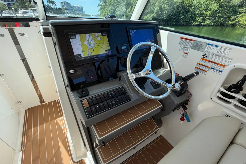 Slide: The Image of 2016 Pursuit DC 325 Dual Console helm with navigation display and steering wheel. - 32