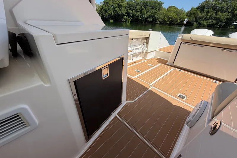 Slide: The Image of 2016 Pursuit DC 325 Dual Console boat interior with teak flooring and storage compartments. - 24