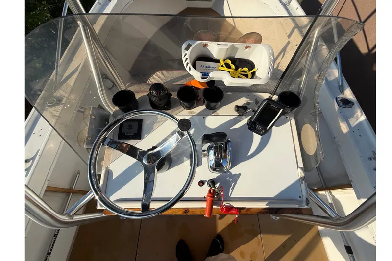 Slide: The Image of 1977 Mako 235 boat dashboard with steering wheel, controls, and navigation equipment. - 25