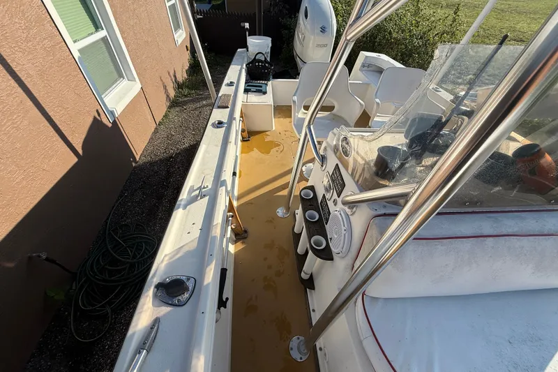 Slide: The Image of 1977 Mako 235 boat interior with steering console, rod holders, and seating. - 17