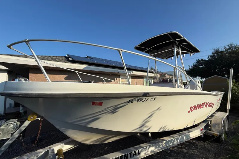 The Image of 1977 Mako 235 boat on trailer, parked outdoors under clear sky. - 0