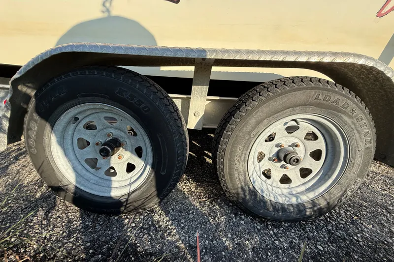Slide: The Image of Trailer wheels of a 1977 Mako 235 boat on gravel surface. - 40