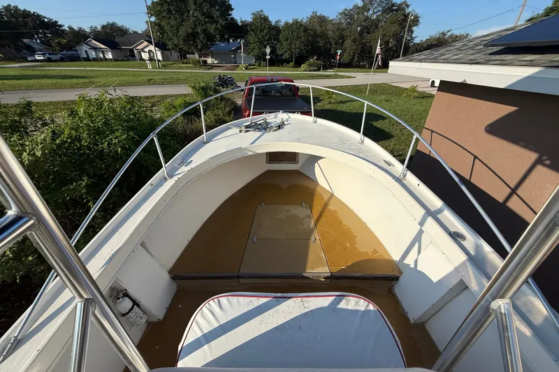 Slide: The Image of 1977 Mako 235 boat deck with railing, parked in a residential area. - 32