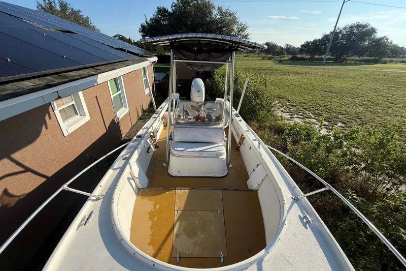 Slide: The Image of 1977 Mako 235 boat with canopy, parked beside a house with solar panels. - 13