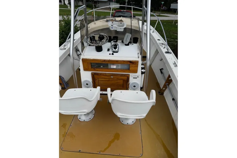Slide: The Image of 1977 Mako 235 boat interior with dual white seats and wooden console. - 4