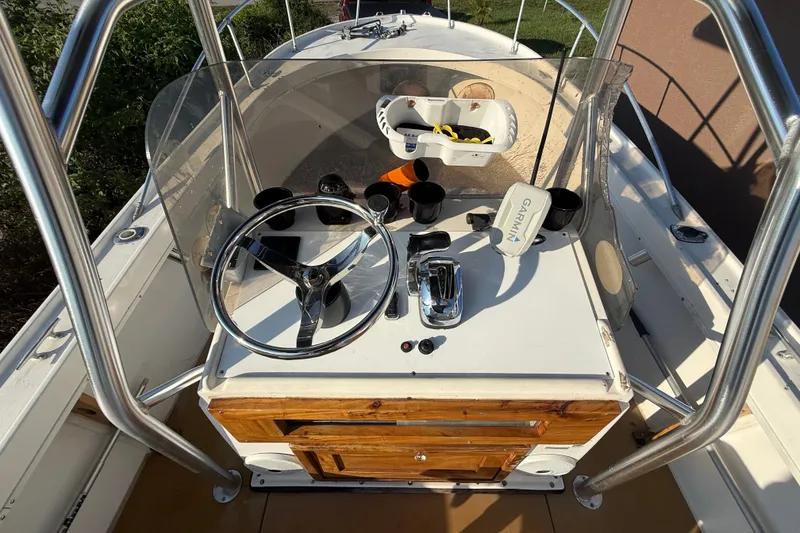 Slide: The Image of 1977 Mako 235 boat console with steering wheel, controls, and Garmin device. - 24