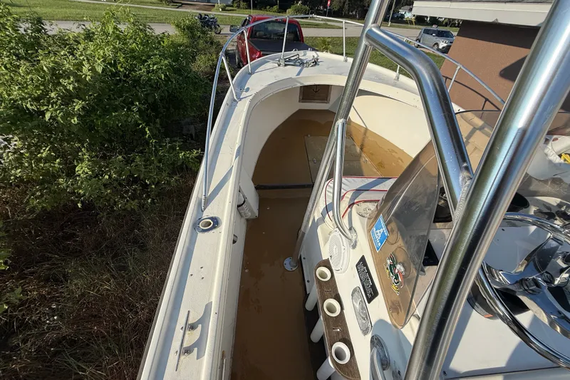 Slide: The Image of 1977 Mako 235 boat with stainless steel railings, parked near greenery. - 29