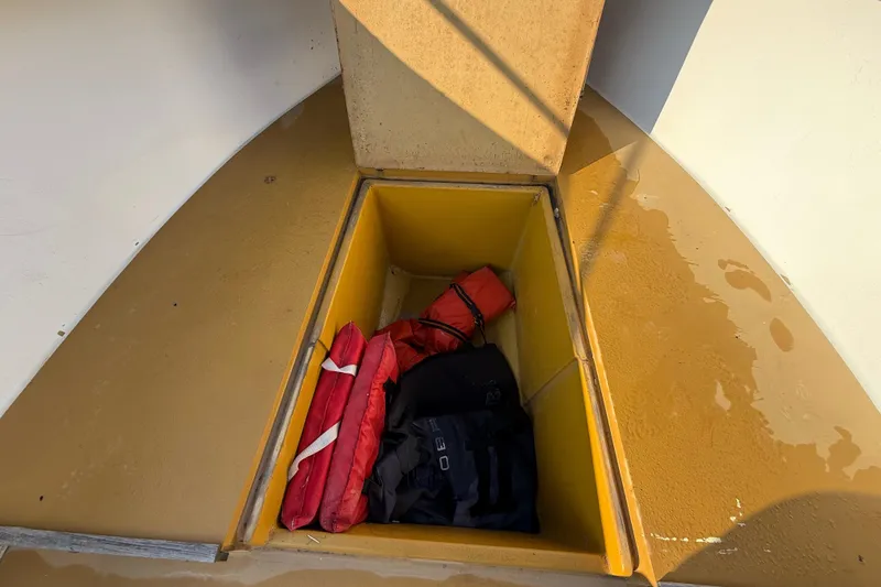 Slide: The Image of An open storage compartment on a boat with life jackets and a bag. - 35