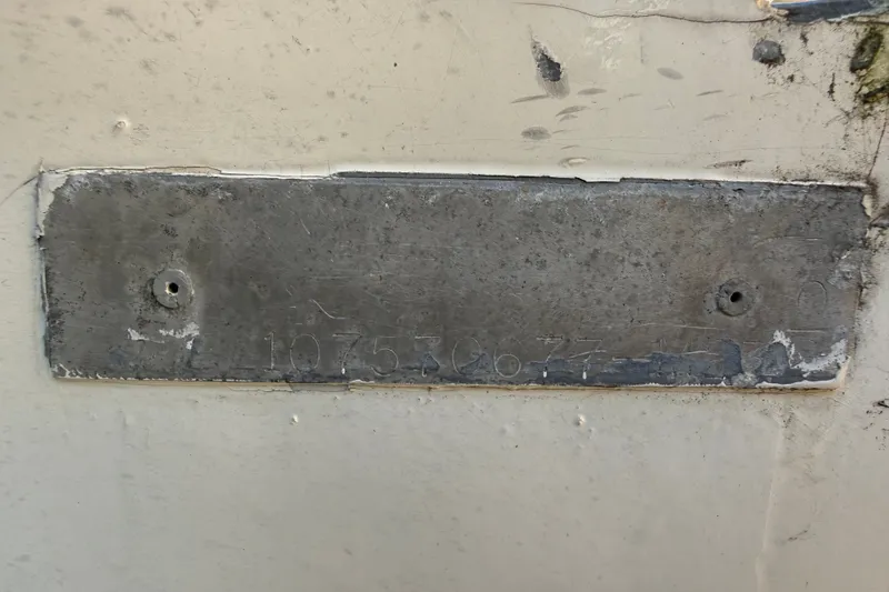 Slide: The Image of Weathered metal identification plate on a 1977 Mako 235 boat hull. - 42
