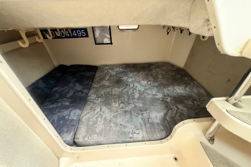 Slide: The Image of 1996 Grady-White Marlin 300 cabin interior with cushioned sleeping area and storage hooks. - 12