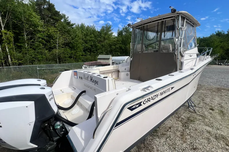 Slide: The Image of 1996 Grady-White Marlin 300 boat with dual engines, parked outdoors on gravel. - 5