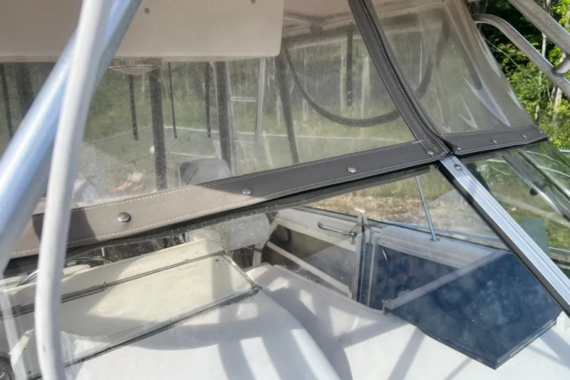 Slide: The Image of 1996 Grady-White Marlin 300 boat cockpit with clear enclosure and metal framework. - 32