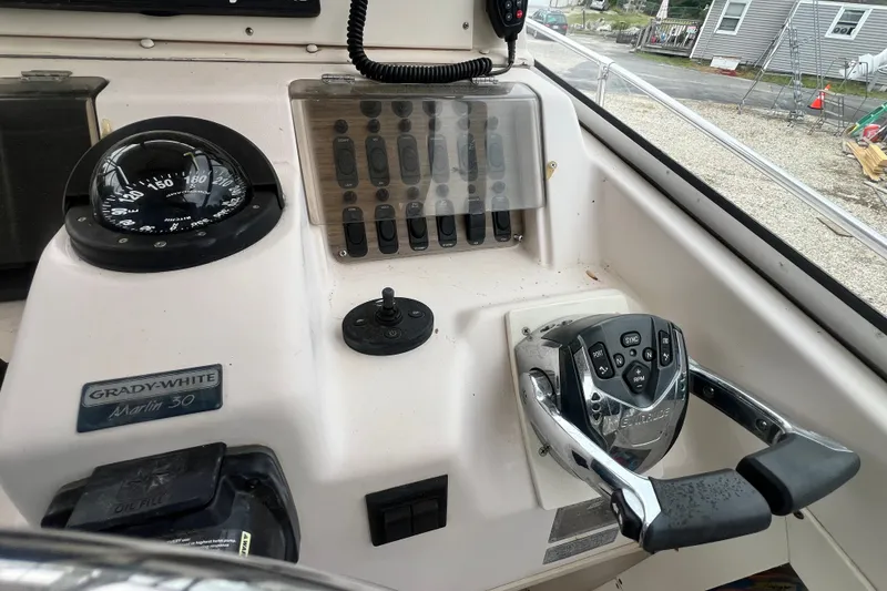 Slide: The Image of Control panel of a 1996 Grady-White Marlin 300 boat with compass and throttle. - 9