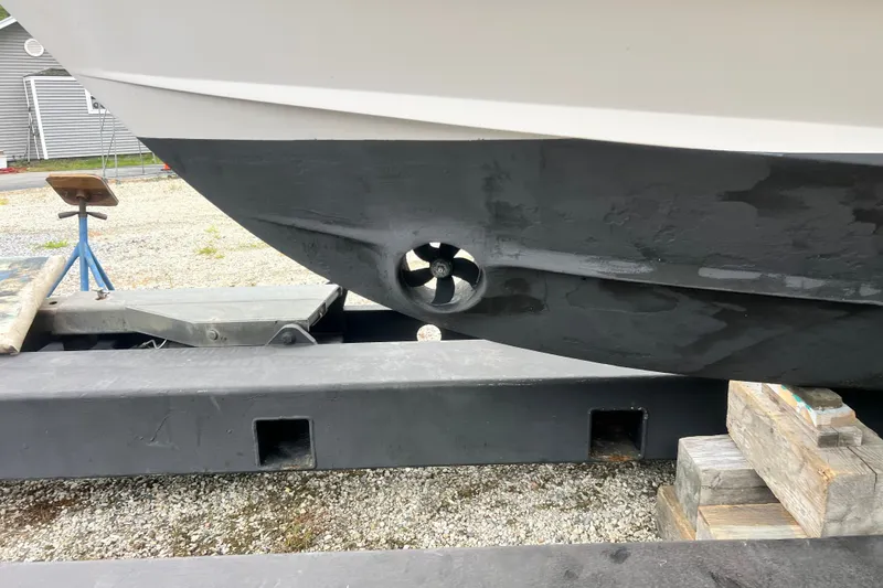 Slide: The Image of 1996 Grady-White Marlin 300 boat hull with visible thruster, on a trailer. - 27