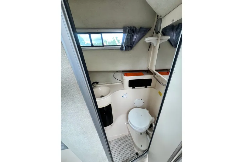 Slide: The Image of 1996 Grady-White Marlin 300 boat bathroom with toilet, sink, and window. - 10