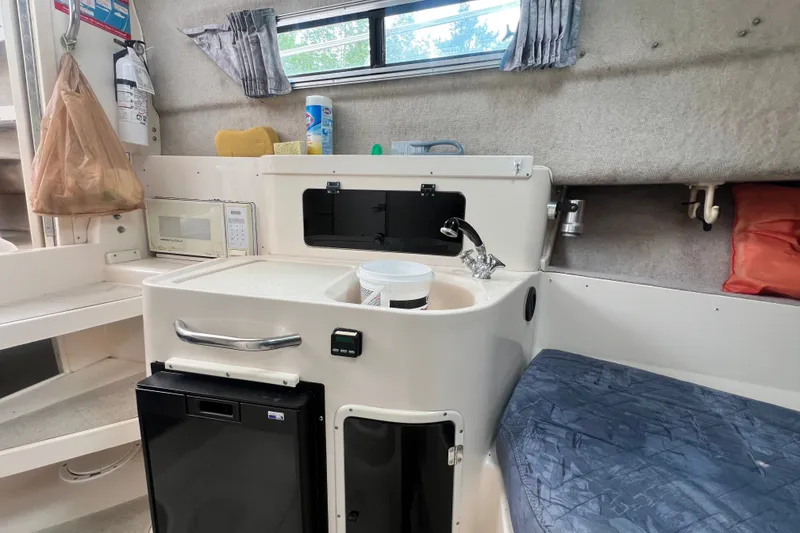 Slide: The Image of Interior of a 1996 Grady-White Marlin 300 boat featuring a compact kitchenette. - 19