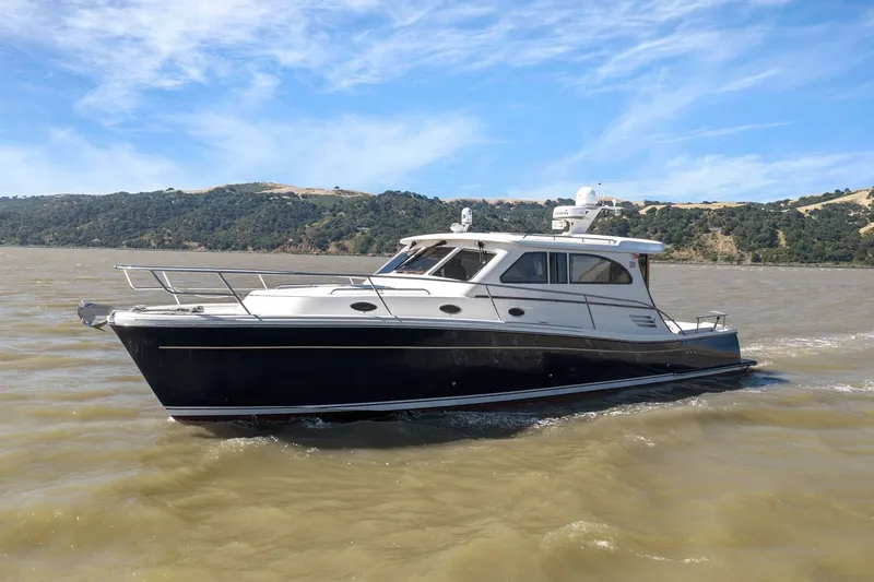Slide: The Image of 2009 Rivolta Coupe 4.5 yacht cruising on a scenic lake with hills in the background. - 18