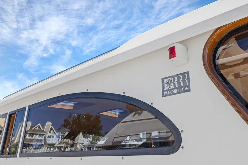 Slide: The Image of 2009 Rivolta Coupe 4.5 boat exterior with logo, under a clear blue sky. - 66