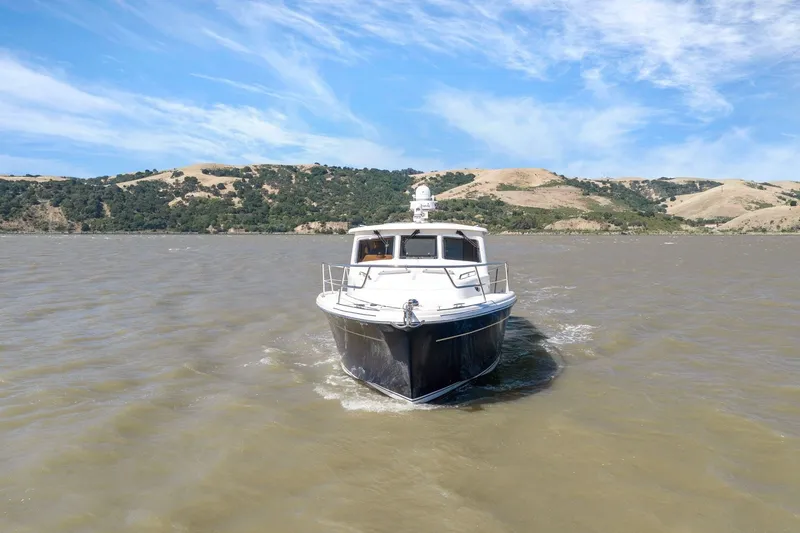 Slide: The Image of 2009 Rivolta Coupe 4.5 boat cruising on a scenic lake with hills in the background. - 17