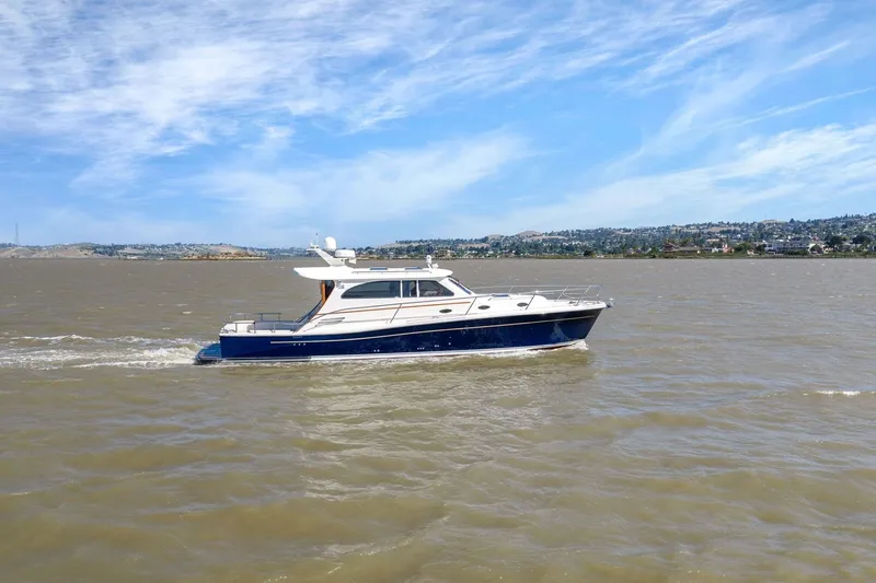 Slide: The Image of 2009 Rivolta Coupe 4.5 yacht cruising on a sunny day with scenic shoreline. - 15