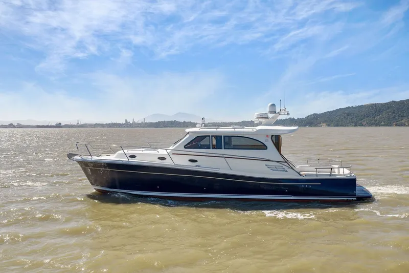 Slide: The Image of 2009 Rivolta Coupe 4.5 yacht cruising on a sunny day with scenic coastal backdrop. - 19