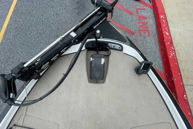 Slide: The Image of 2008 Nitro Z-7 boat bow with trolling motor and fish finder near red curb. - 13