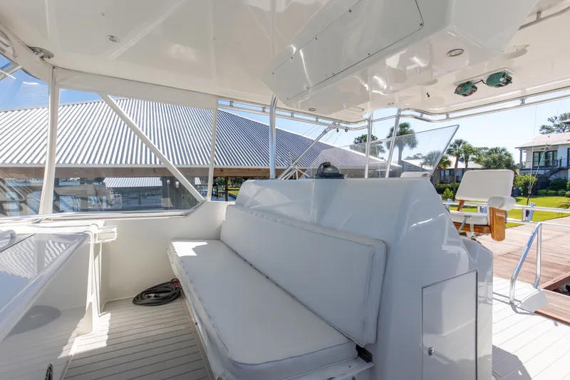 Slide: The Image of Interior view of 1998 Hatteras 60 Convertible yacht with white seating and outdoor scenery. - 34