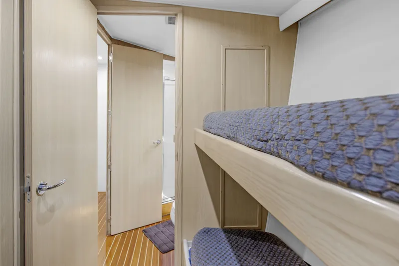 Slide: The Image of Interior of 1998 Hatteras 60 Convertible yacht with bunk beds and wooden flooring. - 16