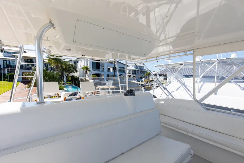 Slide: The Image of Interior view of a 1998 Hatteras 60 Convertible yacht, showcasing seating and marina backdrop. - 35