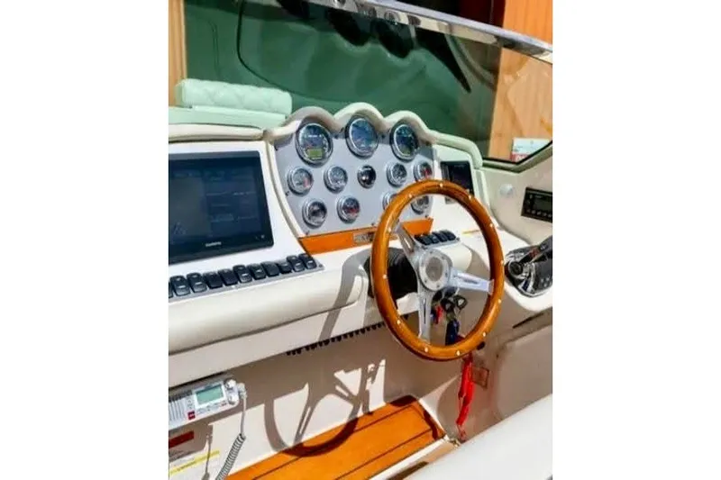Slide: The Image of 2013 Chris-Craft Corsair 32 dashboard with wooden steering wheel and modern gauges. - 7