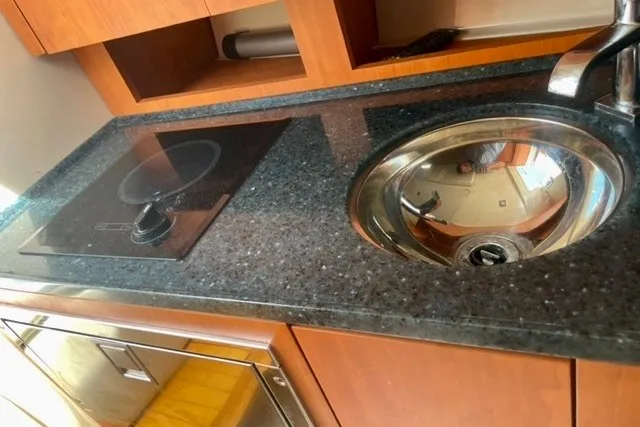 Slide: The Image of 2013 Chris-Craft Corsair 32 yacht kitchen with sleek countertop, sink, and stove. - 16