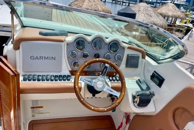 Slide: The Image of 2013 Chris-Craft Corsair 32 dashboard with Garmin navigation and classic wooden steering wheel. - 6