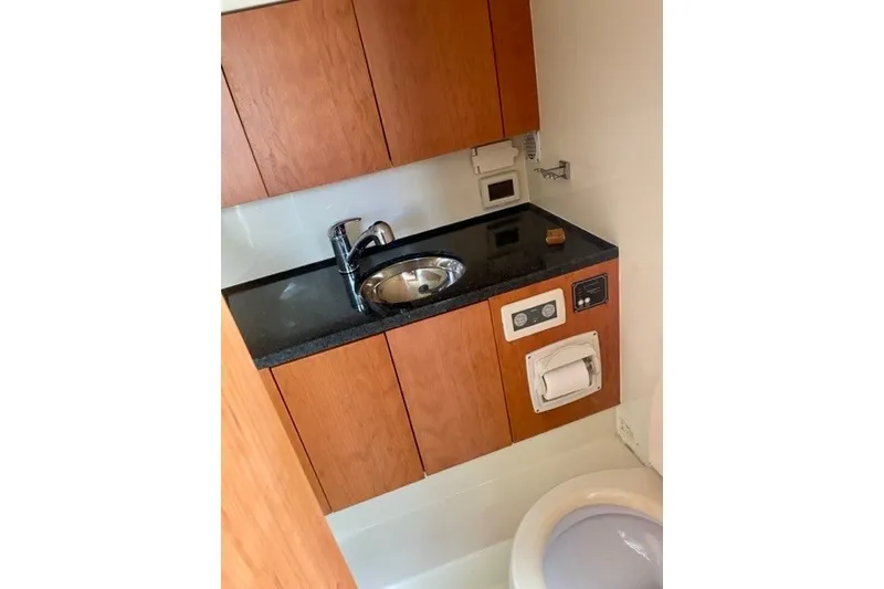 Slide: The Image of 2013 Chris-Craft Corsair 32 boat bathroom with wooden cabinets and sink. - 15