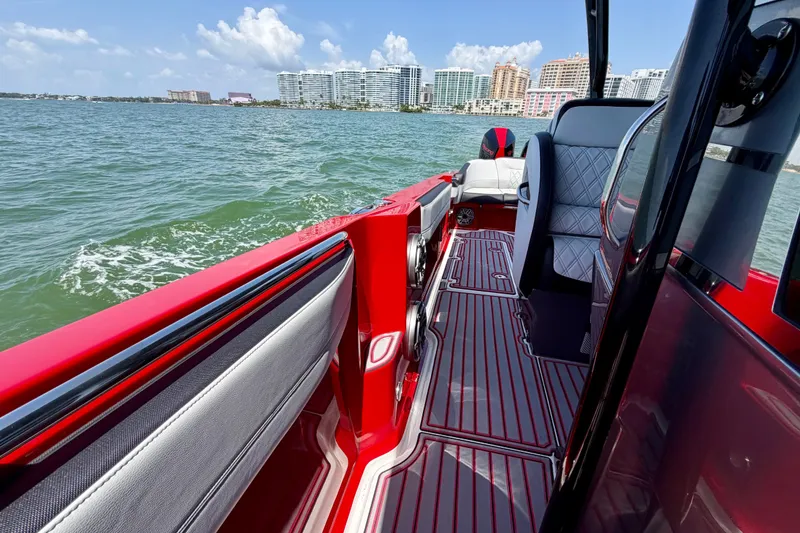 Slide: The Image of 2022 Nor-Tech 390 Sport boat interior with red accents, cruising on a sunny day. - 42