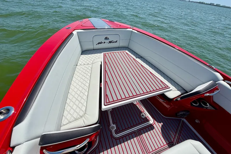 Slide: The Image of Red 2022 Nor-Tech 390 Sport boat interior with stylish seating and table on the water. - 35