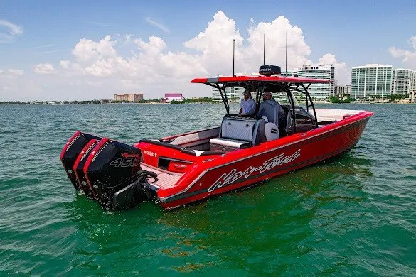 Slide: The Image of 2022 Nor-Tech 390 Sport boat on water, red exterior, twin engines, city skyline background. - 3